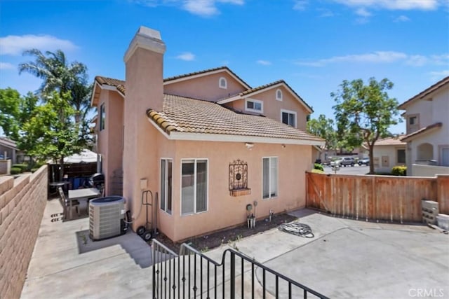 2285 Arabian Way, Corona, CA 92879 - back of property with a patio area, a tile roof, a chimney, and a fenced backyard