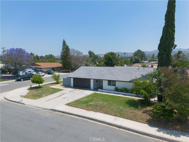 25411 Cottage Ave, Loma Linda, CA 92354 - ranch-style home featuring concrete driveway, a garage, a front lawn, and a mountain view