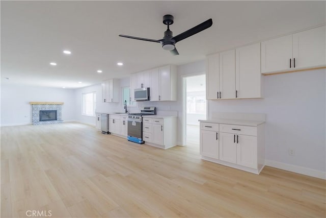 25411 Cottage Ave, Loma Linda, CA 92354 - kitchen with stainless steel appliances, ceiling fan, light wood-style flooring, light countertops, and white cabinets