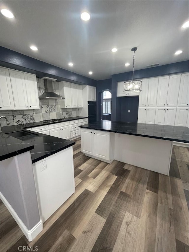 2431 Elizabeth Ct, Upland, CA 91784 - kitchen with wall chimney range hood, dark countertops, wood finished floors, white cabinets, and recessed lighting