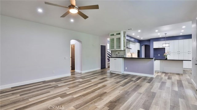 2431 Elizabeth Ct, Upland, CA 91784 - unfurnished living room featuring arched walkways, ceiling fan, light wood-type flooring, and recessed lighting