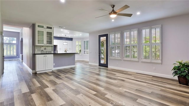 2431 Elizabeth Ct, Upland, CA 91784 - unfurnished living room featuring healthy amount of natural light, arched walkways, a ceiling fan, light wood-style floors, and recessed lighting