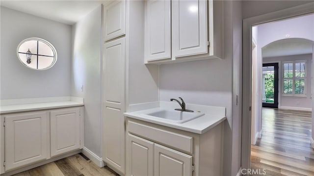 2431 Elizabeth Ct, Upland, CA 91784 - laundry area featuring light wood-style floors and arched walkways