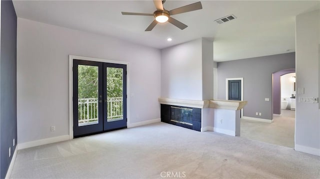 2431 Elizabeth Ct, Upland, CA 91784 - unfurnished living room featuring light colored carpet, french doors, arched walkways, and a ceiling fan