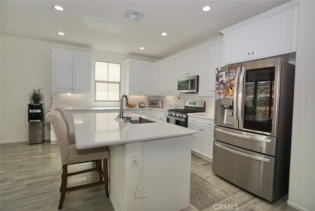 3042 Eveningcloud St, Hemet, CA 92543 - kitchen featuring stainless steel appliances, a sink, white cabinetry, light wood finished floors, and recessed lighting