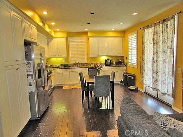 3981 E Emory Ln Unit 6, Ontario, CA 91761 - kitchen featuring stainless steel appliances, dark wood-type flooring, recessed lighting, white cabinetry, and dark stone countertops