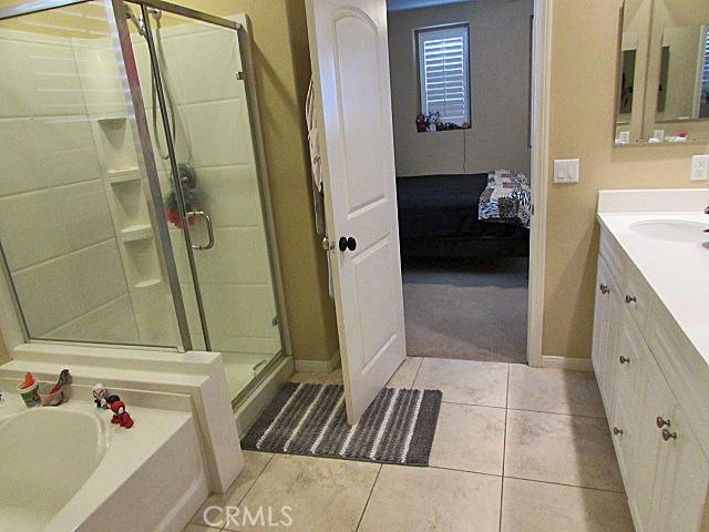 3981 E Emory Ln Unit 6, Ontario, CA 91761 - bathroom featuring vanity, baseboards, a shower stall, and ensuite bath