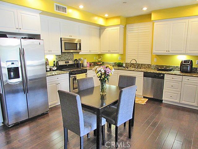 3981 E Emory Ln Unit 6, Ontario, CA 91761 - kitchen featuring appliances with stainless steel finishes, dark wood-style flooring, white cabinetry, a sink, and recessed lighting