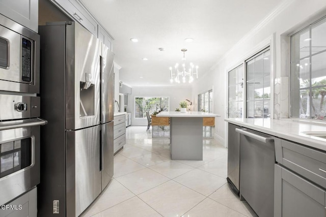 8857 Bluffdale Dr, Sun Valley, CA 91352 - kitchen with stainless steel appliances, gray cabinetry, a chandelier, crown molding, and light countertops