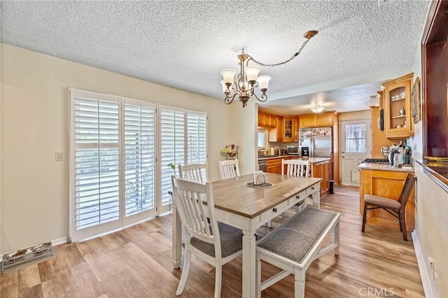 5644 Wadsworth Ave, Highland, CA 92346 - dining space featuring a chandelier, light wood-type flooring, and a textured ceiling