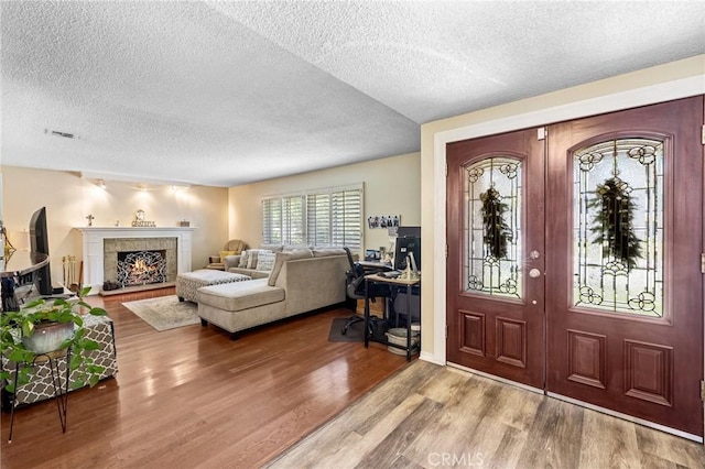5644 Wadsworth Ave, Highland, CA 92346 - entryway featuring a textured ceiling, french doors, wood finished floors, and a warm lit fireplace