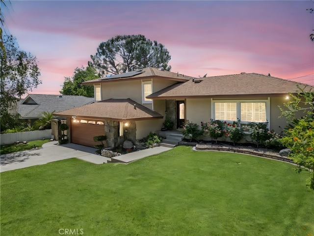 5644 Wadsworth Ave, Highland, CA 92346 - split level home featuring concrete driveway, roof mounted solar panels, a garage, and stucco siding