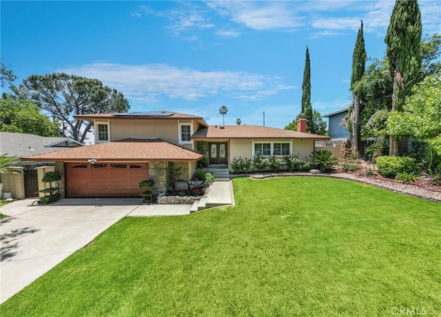 5644 Wadsworth Ave, Highland, CA 92346 - tri-level home featuring stucco siding, an attached garage, solar panels, and driveway