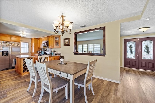 5644 Wadsworth Ave, Highland, CA 92346 - dining room featuring a textured ceiling, a chandelier, and wood finished floors