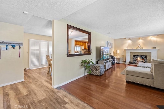 5644 Wadsworth Ave, Highland, CA 92346 - living area with wood finished floors, a textured ceiling, and a tiled fireplace