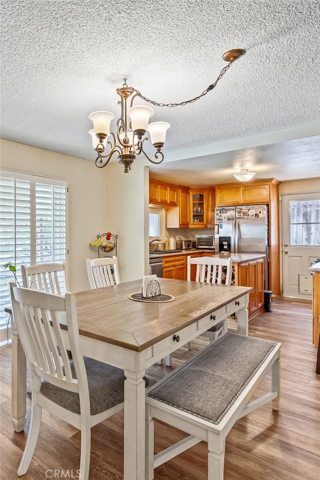5644 Wadsworth Ave, Highland, CA 92346 - dining space with a textured ceiling, light wood finished floors, and a chandelier