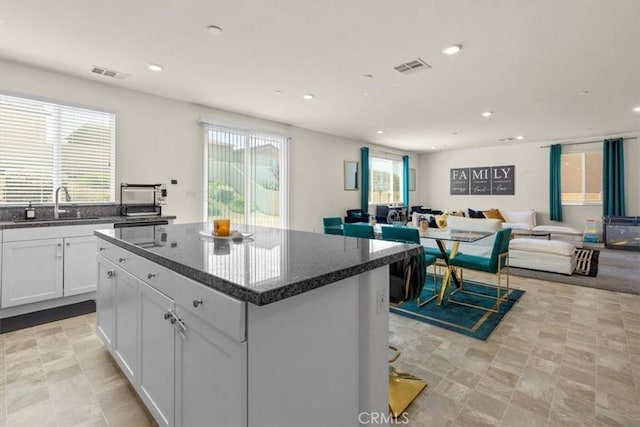 1023 Barberry Ln, Calimesa, CA 92320 - kitchen featuring recessed lighting, a sink, a kitchen island, white cabinets, and dark stone counters