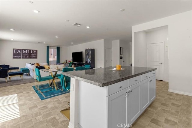 1023 Barberry Ln, Calimesa, CA 92320 - kitchen featuring white cabinetry, a center island, recessed lighting, open floor plan, and baseboards