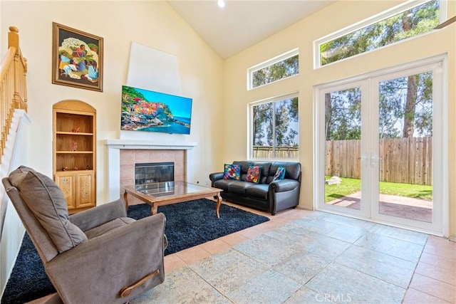 24101 Crowned Partridge Ln, Murrieta, CA 92562 - living room with french doors, high vaulted ceiling, a tile fireplace, tile patterned flooring, and stairs