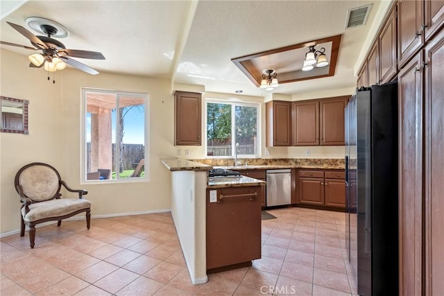24101 Crowned Partridge Ln, Murrieta, CA 92562 - kitchen featuring stainless steel appliances, a peninsula, light stone counters, a ceiling fan, and light tile patterned floors