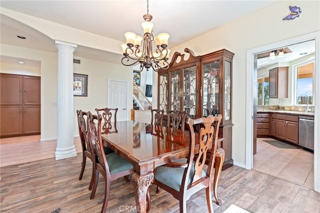 24101 Crowned Partridge Ln, Murrieta, CA 92562 - dining room featuring a chandelier, light wood-type flooring, stairway, and ornate columns