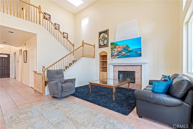 24101 Crowned Partridge Ln, Murrieta, CA 92562 - living room with a towering ceiling, built in shelves, tile patterned flooring, stairs, and a fireplace