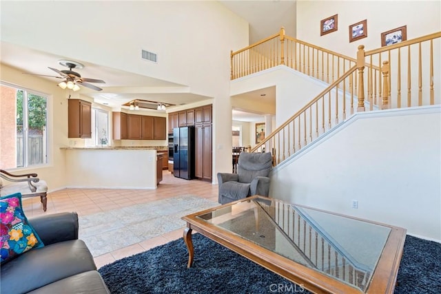 24101 Crowned Partridge Ln, Murrieta, CA 92562 - living area featuring a ceiling fan, light tile patterned flooring, stairway, and a high ceiling