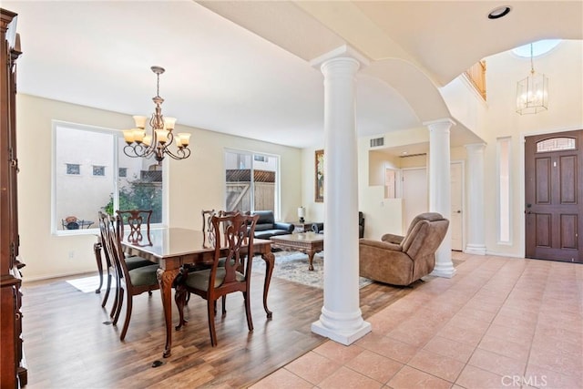24101 Crowned Partridge Ln, Murrieta, CA 92562 - dining room with a chandelier, arched walkways, light wood-type flooring, and ornate columns