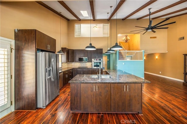 27470 Lakeview Dr, Helendale, CA 92342 - kitchen with stainless steel appliances, a sink, dark brown cabinetry, beamed ceiling, and dark stone countertops