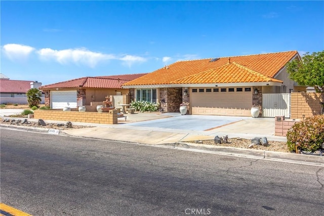 27470 Lakeview Dr, Helendale, CA 92342 - view of front of property featuring a tiled roof, a garage, driveway, stone siding, and stucco siding