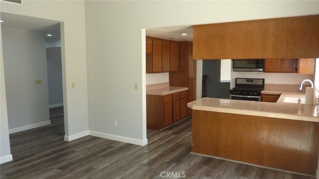 284 Celeste Dr, Riverside, CA 92507 - kitchen with black gas stove, stainless steel microwave, brown cabinetry, light countertops, and recessed lighting