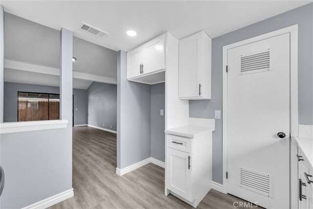12830 Perris Blvd Unit C10, Moreno Valley, CA 92553 - kitchen featuring light wood-type flooring, white cabinetry, baseboards, light countertops, and recessed lighting