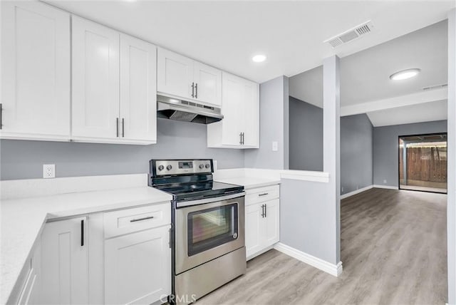 12830 Perris Blvd Unit C10, Moreno Valley, CA 92553 - kitchen with electric range, under cabinet range hood, baseboards, light countertops, and light wood-type flooring