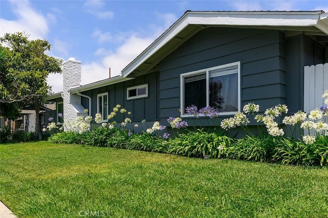 17132 Emerald Ln, Huntington Beach, CA 92647 - view of property exterior featuring board and batten siding, a chimney, and a lawn