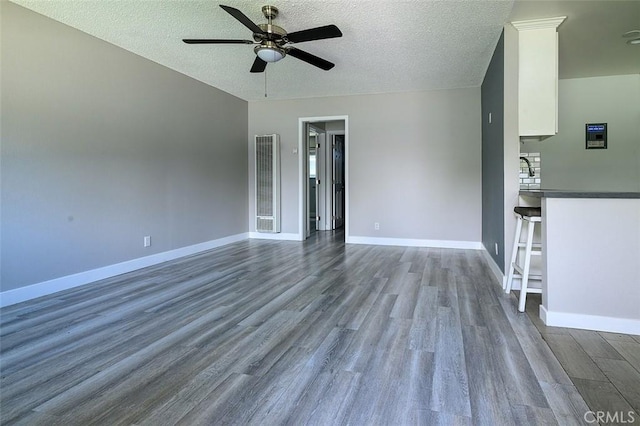 17132 Emerald Ln, Huntington Beach, CA 92647 - spare room featuring ceiling fan, wood finished floors, baseboards, a textured ceiling, and a heating unit