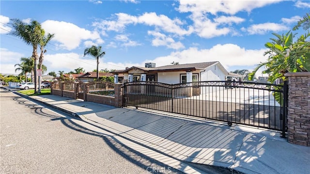 9828 Carob Ave, Fontana, CA 92335 - ranch-style home featuring a gate, a fenced front yard, stucco siding, and driveway