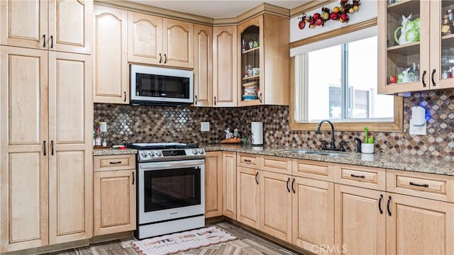 9828 Carob Ave, Fontana, CA 92335 - kitchen with stainless steel appliances, light brown cabinetry, light stone countertops, and backsplash