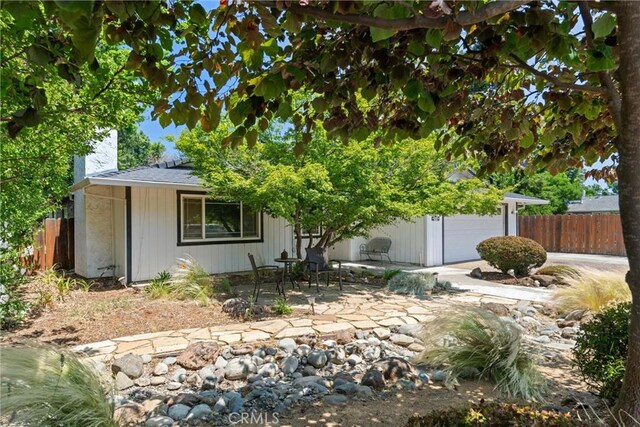3030 Silverbell Rd, Chico, CA 95973 - view of property hidden behind natural elements featuring a chimney, a patio area, and an attached garage