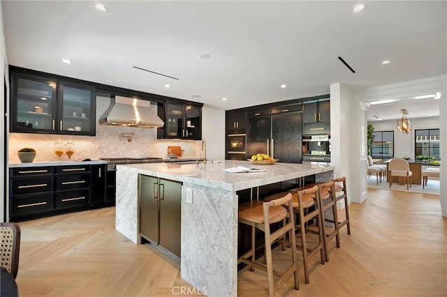 9363 Dinsdale St, Downey, CA 90240 - kitchen featuring wall chimney range hood, dark cabinetry, tasteful backsplash, paneled built in refrigerator, and a sink