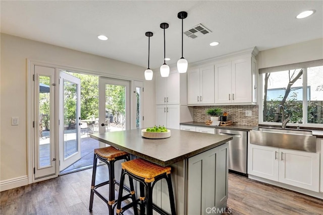 55 Fairfield, Lake Forest, CA 92610 - kitchen featuring stainless steel dishwasher, dark countertops, plenty of natural light, wood finished floors, and recessed lighting