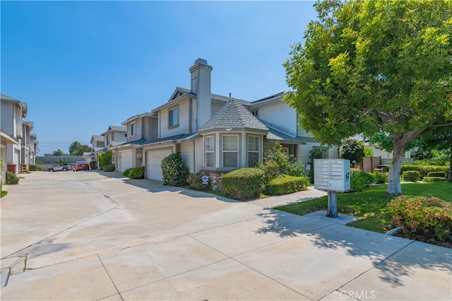 530 Diamond St Unit C, Monrovia, CA 91016 - view of side of home featuring mail area, driveway, a chimney, a garage, and a residential view