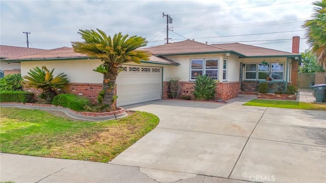 14012 S Wilkie Ave, Gardena, CA 90249 - view of front of home featuring stucco siding, driveway, a garage, brick siding, and a front yard