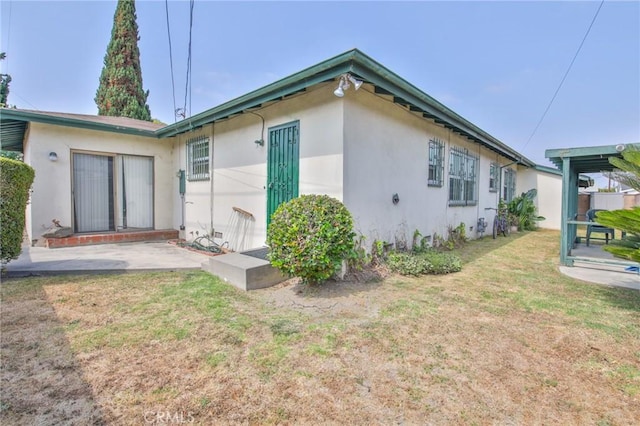 14012 S Wilkie Ave, Gardena, CA 90249 - view of side of property featuring stucco siding, a yard, and a patio area
