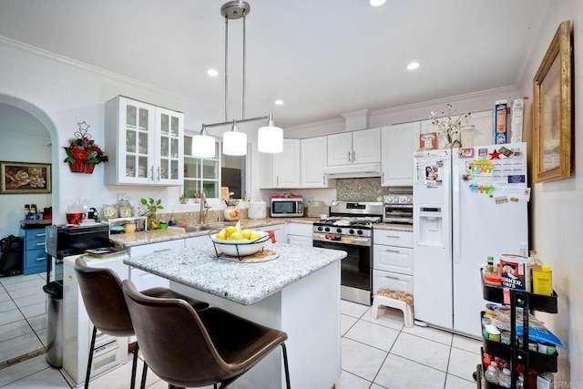 1965 Galvez Ct, San Diego, CA 92154 - kitchen featuring appliances with stainless steel finishes, light tile patterned floors, crown molding, under cabinet range hood, and a sink