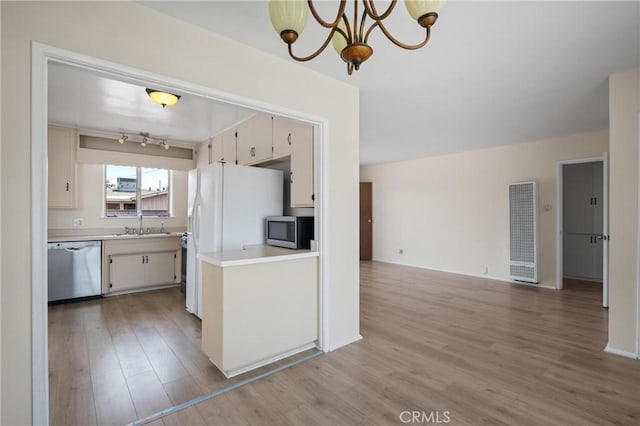 150 E 232nd St, Carson, CA 90745 - kitchen featuring a heating unit, appliances with stainless steel finishes, light countertops, light wood-style flooring, and a chandelier