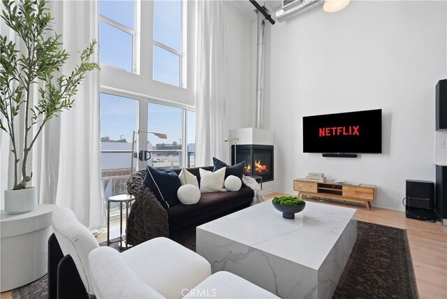 4215 Glencoe Ave Unit 407, Marina Del Rey, CA 90292 - living area with a high ceiling, a fireplace, and light wood-type flooring