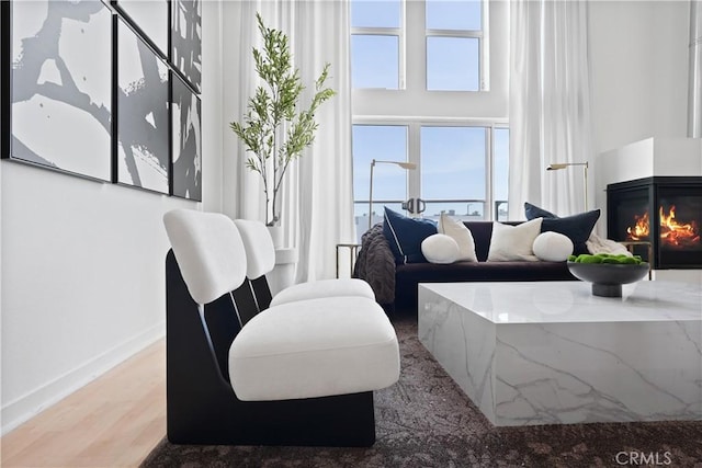 4215 Glencoe Ave Unit 407, Marina Del Rey, CA 90292 - living area featuring a glass covered fireplace, baseboards, and wood finished floors