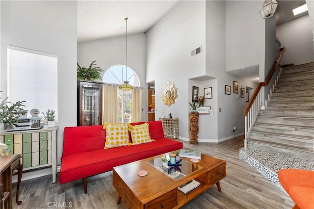 13519 Fremont St, Fontana, CA 92336 - living room featuring wood finished floors, high vaulted ceiling, and stairway