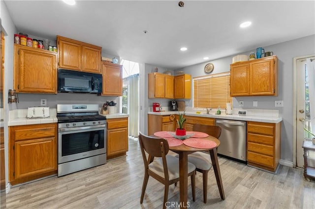 13519 Fremont St, Fontana, CA 92336 - kitchen featuring stainless steel appliances, light wood finished floors, brown cabinets, recessed lighting, and tile countertops