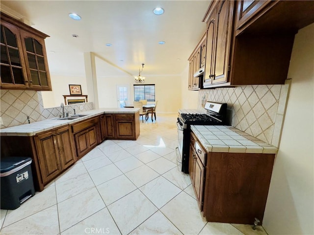 14542 Los Robles Ave, Hacienda Heights, CA 91745 - kitchen featuring gas range, a peninsula, tile counters, a chandelier, and backsplash